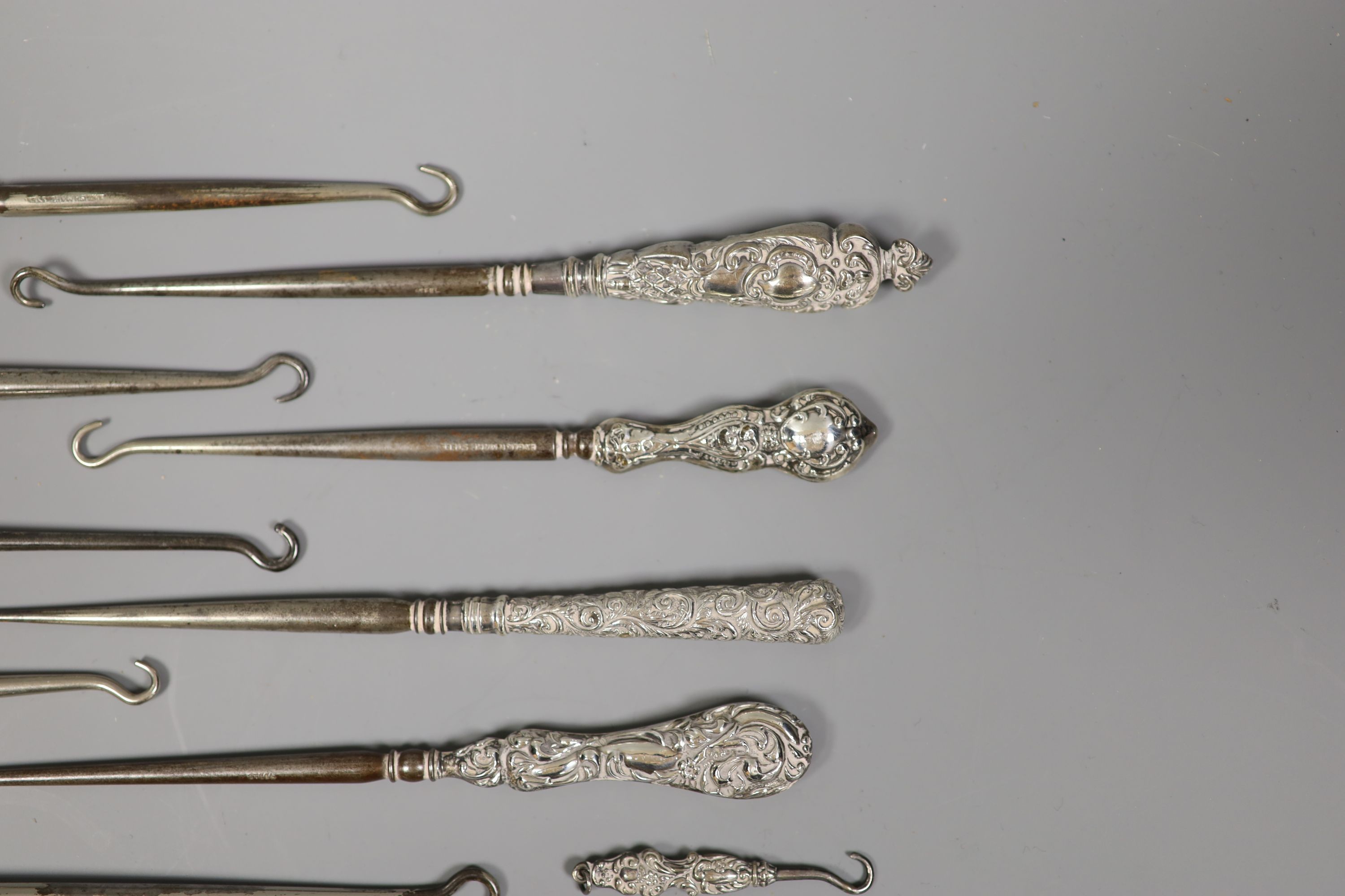 A collection of assorted silver handle button hooks and a nail implement.